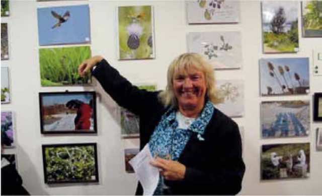 Pasture friend Linda Dolata shows off some of the art work. Photo by Diana Walsh.